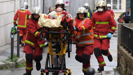 Bombeiros franceses socorrem ferido perto das antigas instalações do jornal 'Charlie Hebdo', em Paris, em 25 de setembro — Foto: Alain Jocard / AFP.